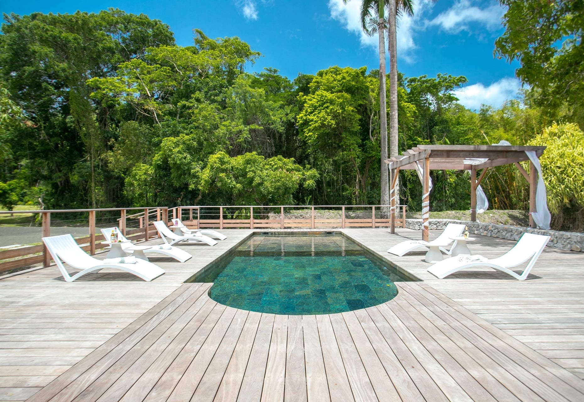 Piscine et deck de bois du domaine, face à la jungle tropicale